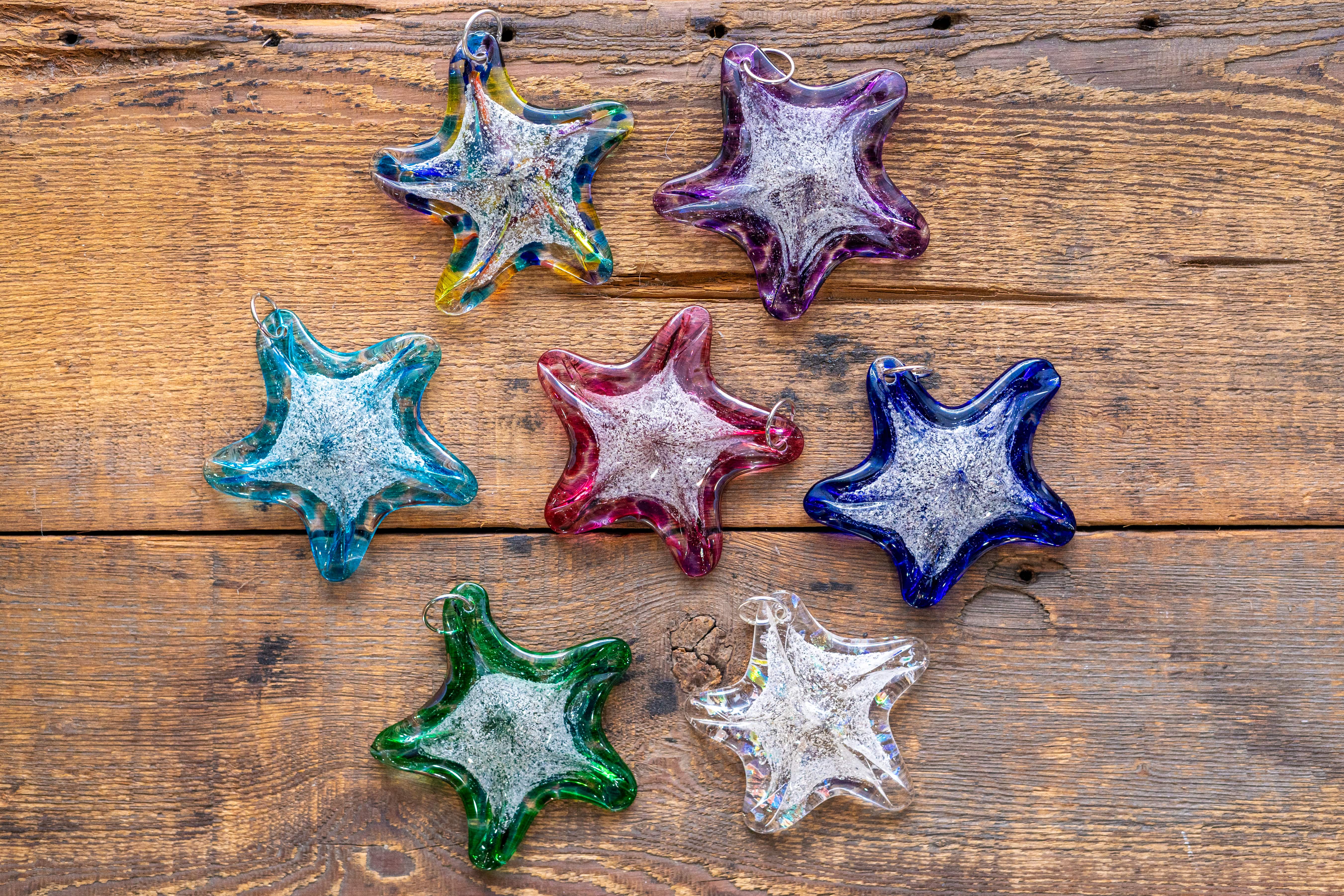 four different colored stars on a wooden surface