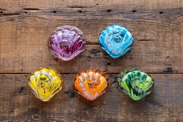 four glass bowls are sitting on a wooden surface