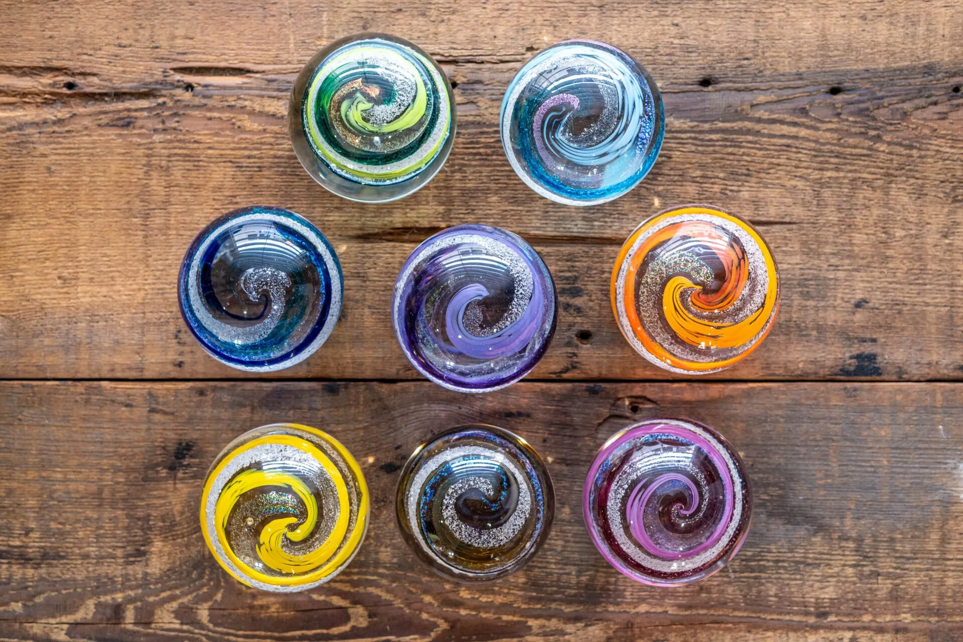 six colorful glass bowls sitting on top of a wooden table